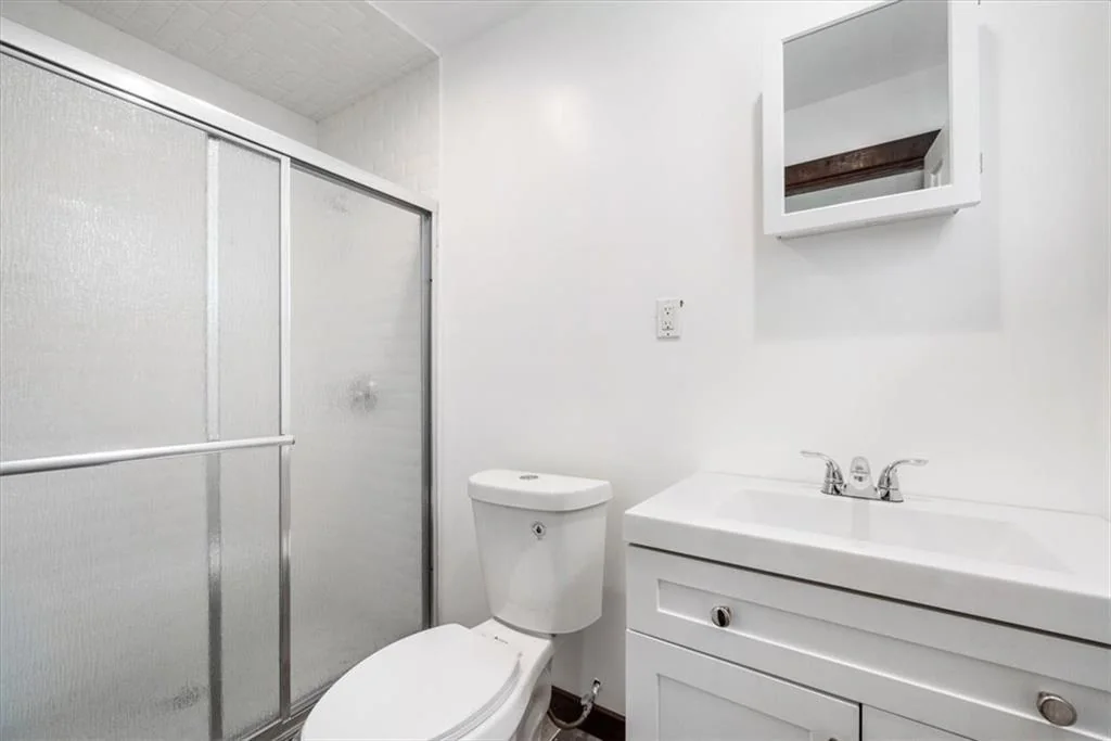 Completed bathroom with shower, vanity, and toilet