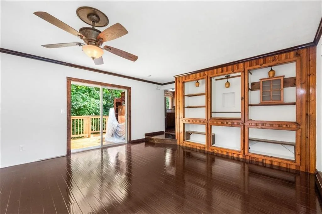 Living area with built-in shelving and deck access