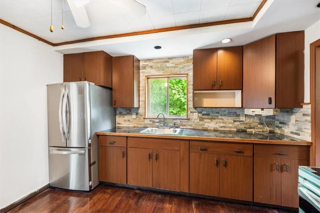 Completed kitchen with wood cabinets and stainless refrigerator