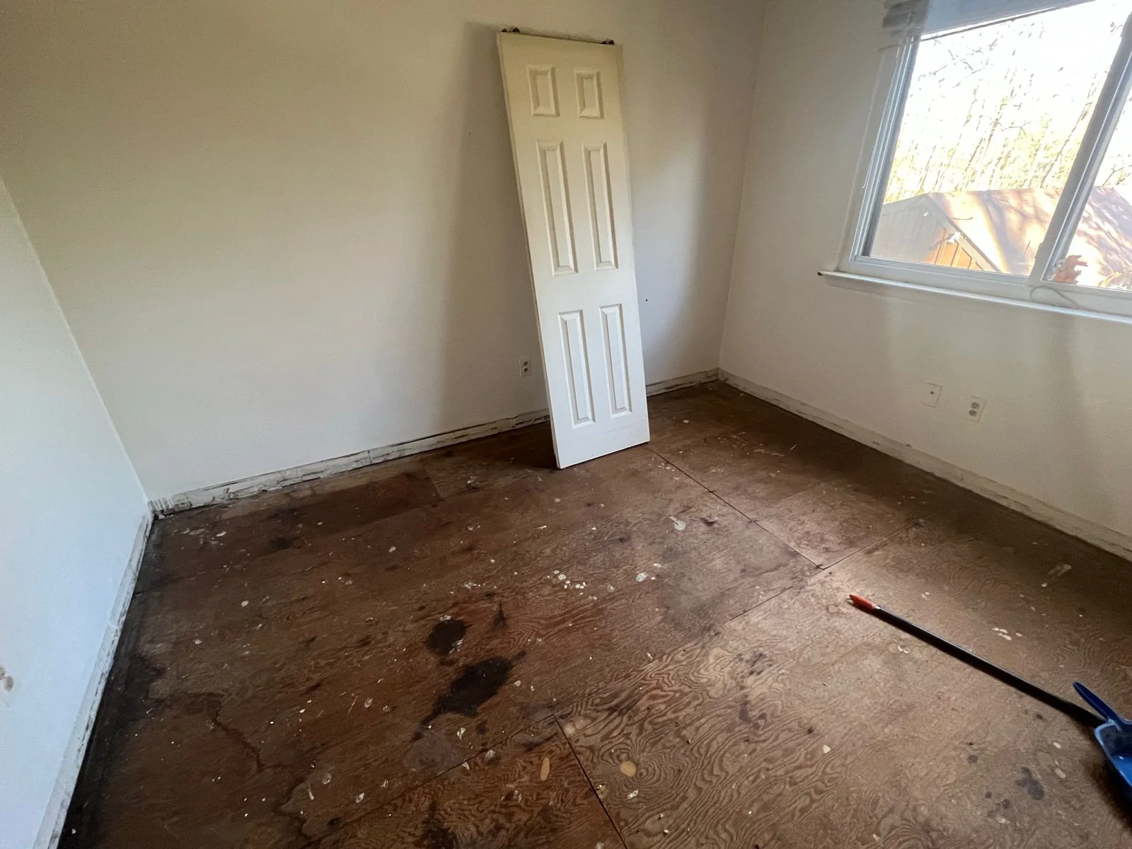 Bedroom stripped to plywood before rehabilitation