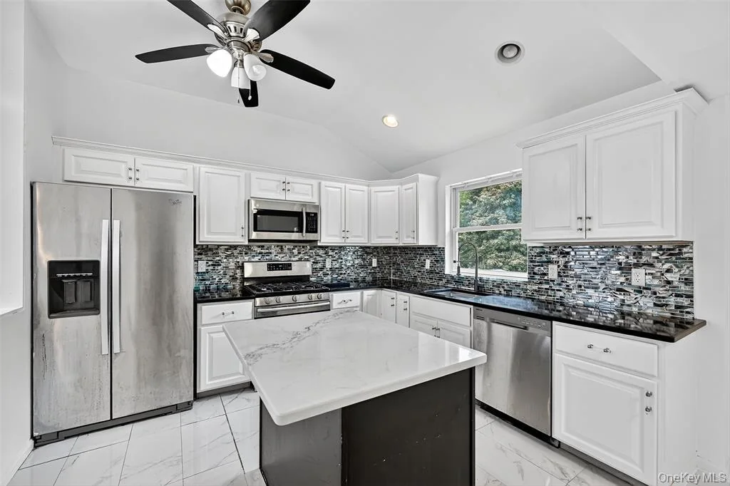 Completed kitchen with island and white cabinets