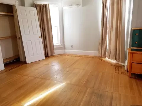 Empty room with original wood floor before the completed conversion