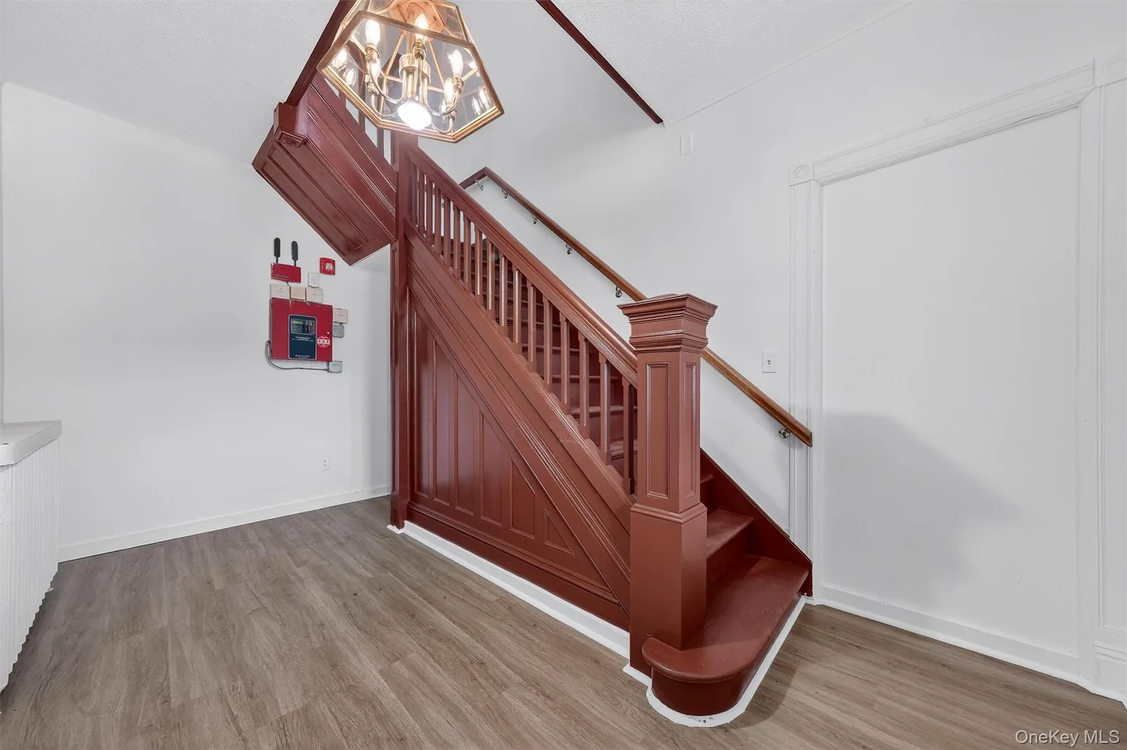 Completed stair hall with rich wood railing and updated flooring