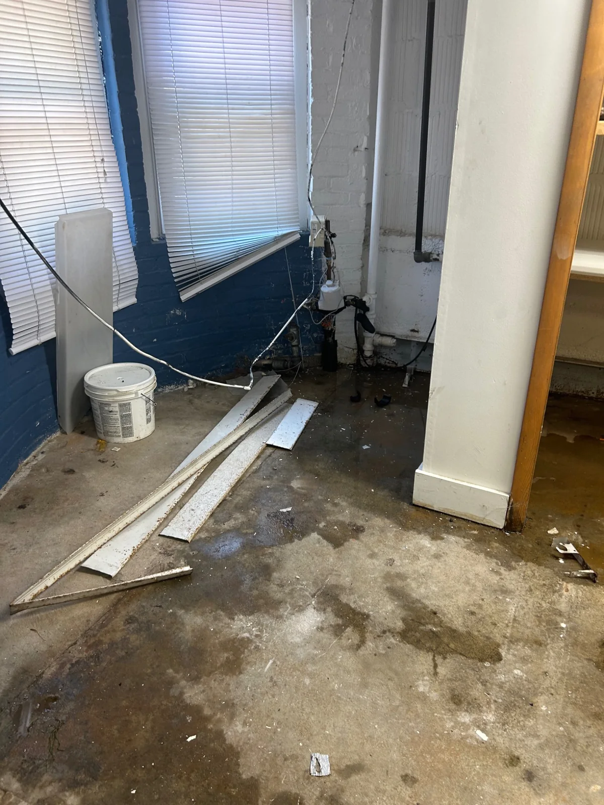 Lower-level area with water staining and removed baseboard covers