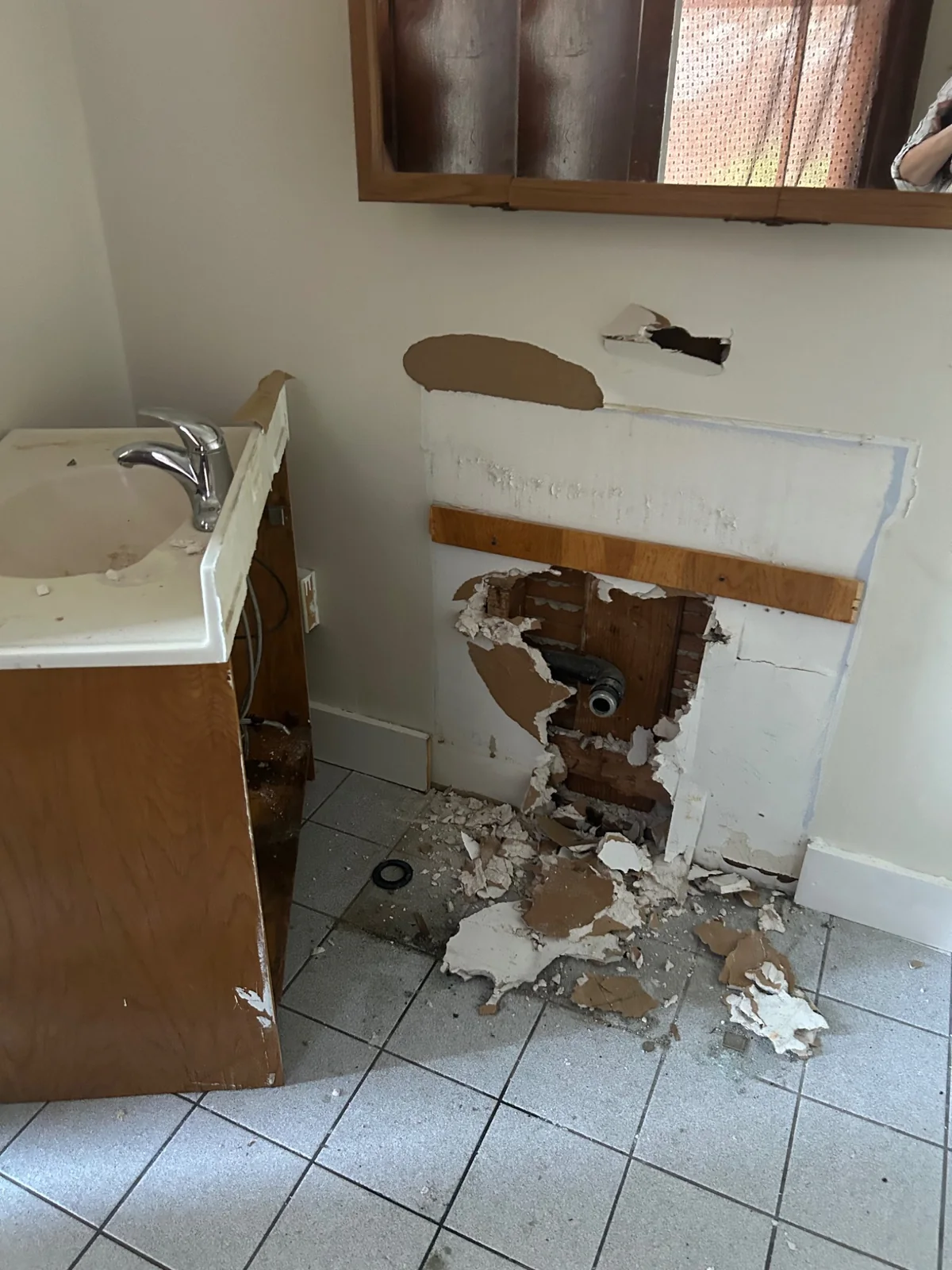 Bathroom wall opening showing plumbing and finish conditions
